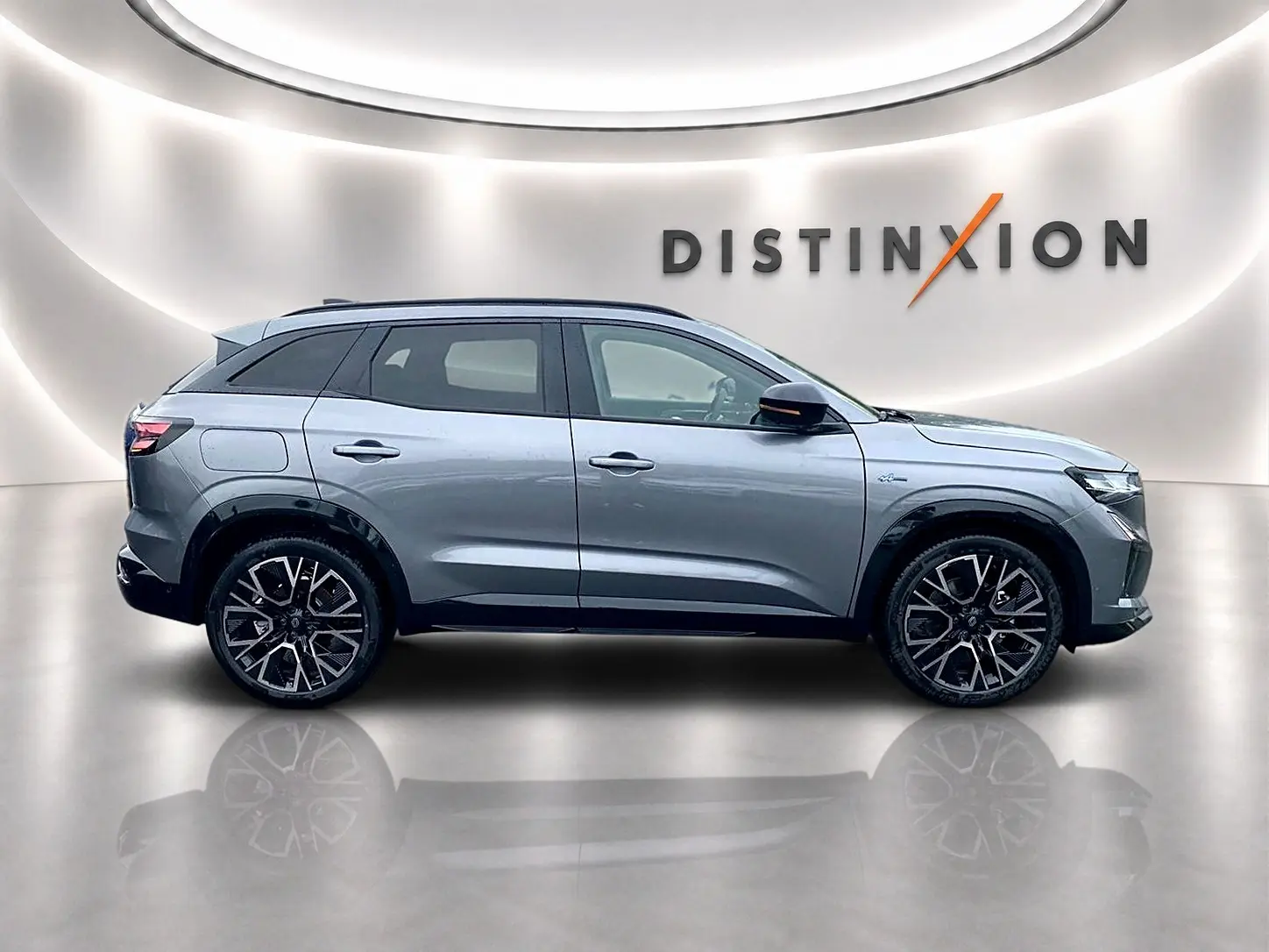 Profil droit du Renault Austral gris schiste avec jantes alu noires et toit noir dans un studio lumineux.