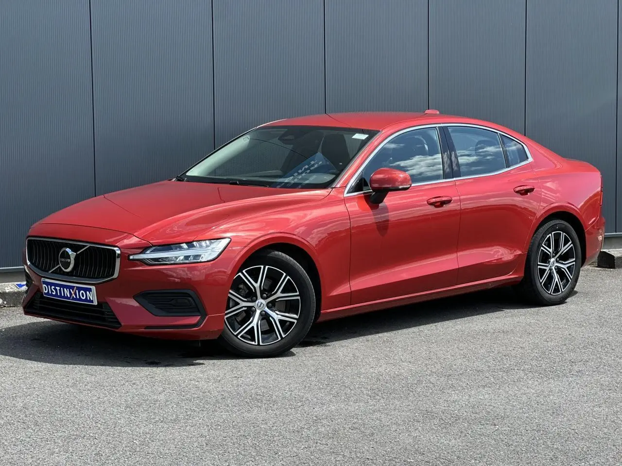Volvo S60 rouge Fusion vue 3/4 avant droit avec jantes alliage 17 pouces et contours de fenêtres chromés.