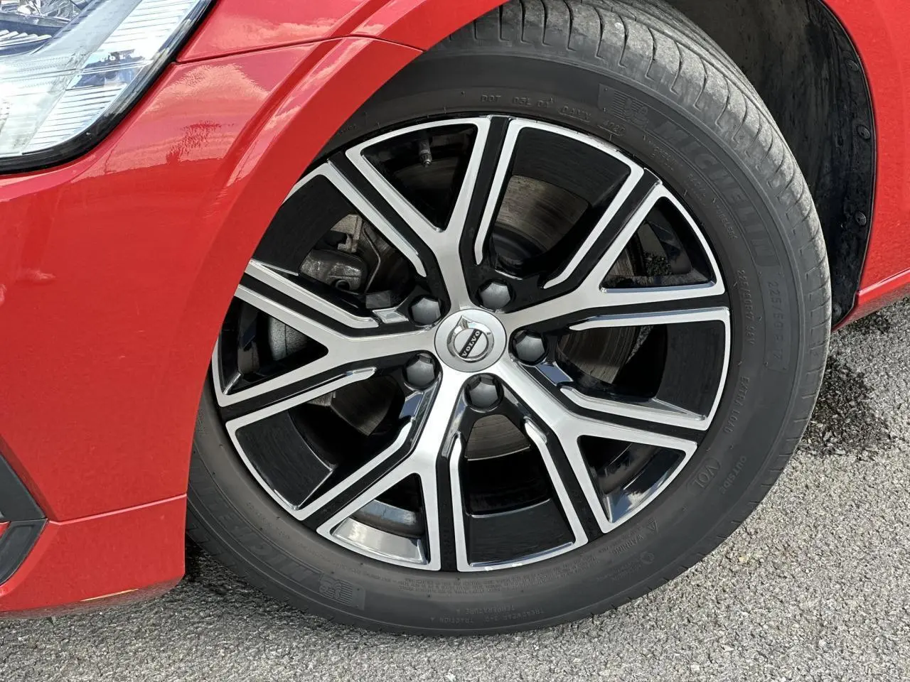 Gros plan sur la jante alliage 17 pouces noir et diamant du côté avant gauche d'une Volvo S60 Rouge Fusion 2024.