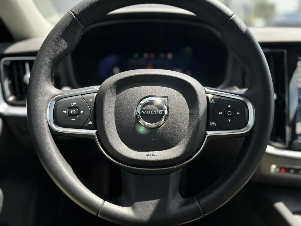 Volant noir de Volvo S60 2024 B4 Core+ avec commandes intégrées, vue frontale centrée sur le volant.