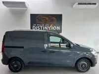 Profil droit d'un Renault Express Van gris 2021 avec porte latérale coulissante et enjoliveurs noirs, en intérieur showroom.