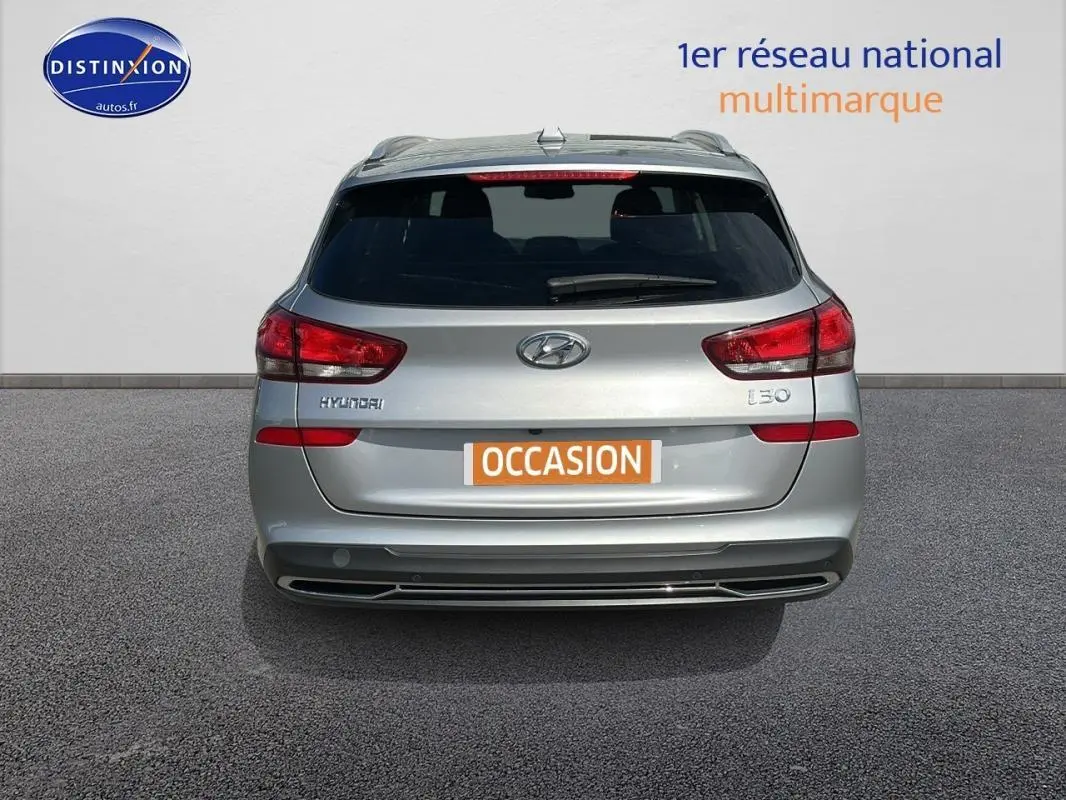 Vue arrière d'une Hyundai i30 SW gris clair avec vitres surteintées et plaque "OCCASION" visible.