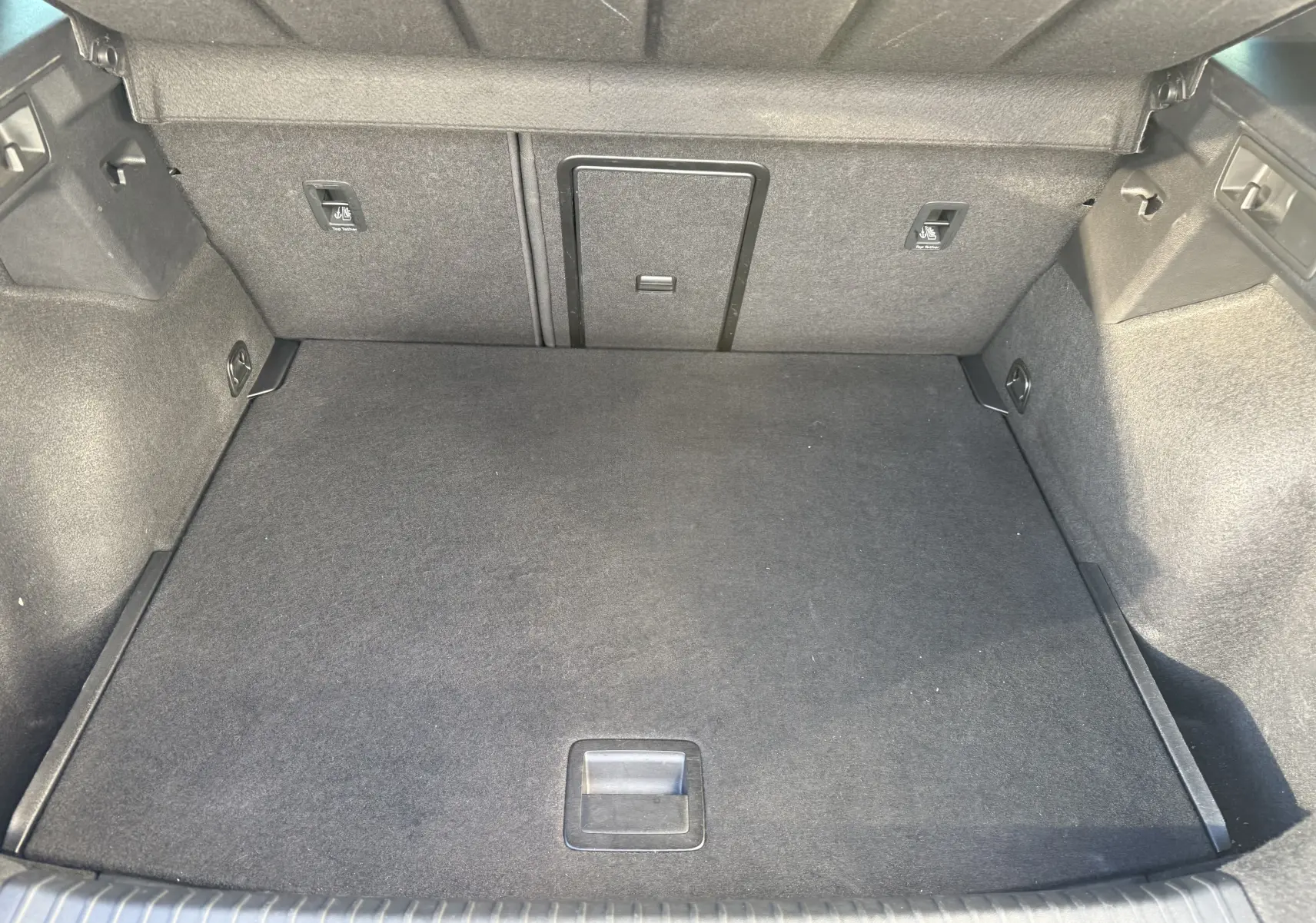 Coffre spacieux et propre du CUPRA Formentor 2023 en noir minuit, vue intérieure depuis l'arrière avec revêtement tissu gris foncé.