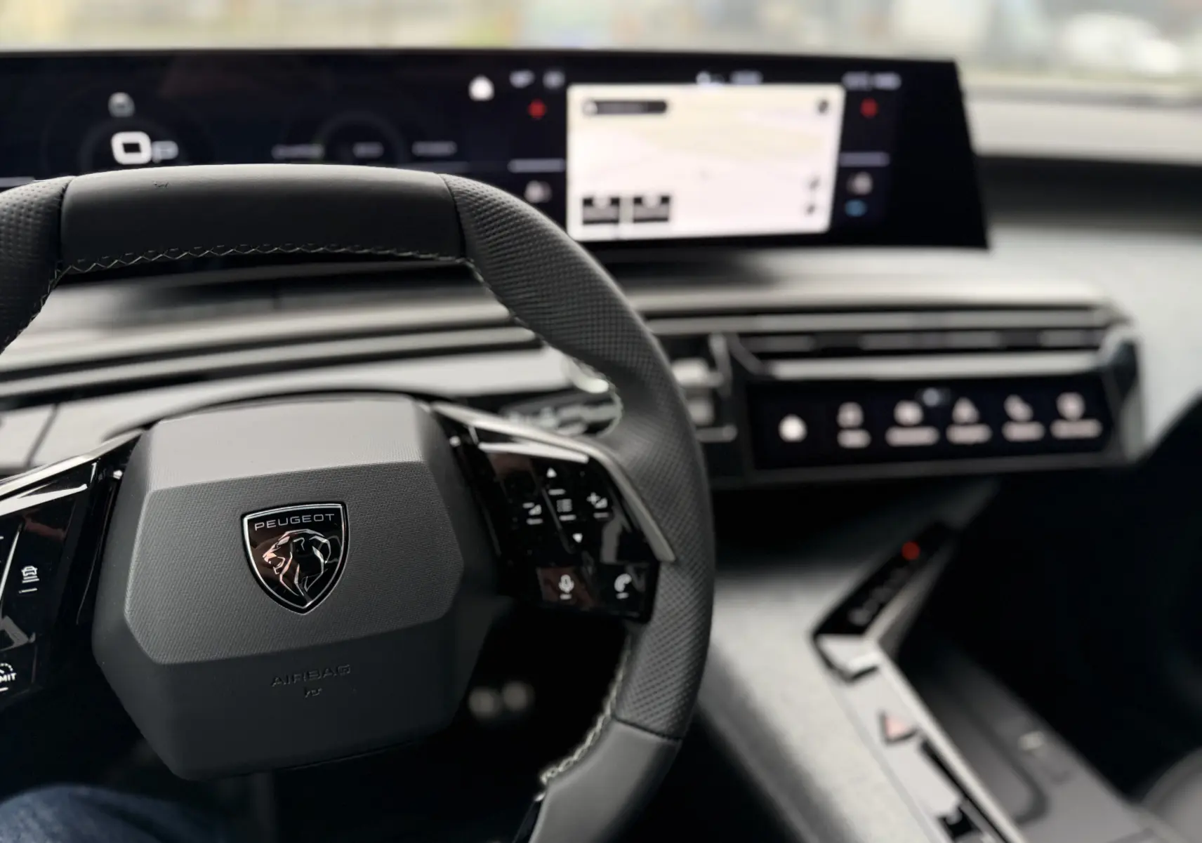 Vue rapprochée du volant et tableau de bord numérique du Peugeot 3008 Hybrid 2025, ambiance intérieure moderne et épurée.