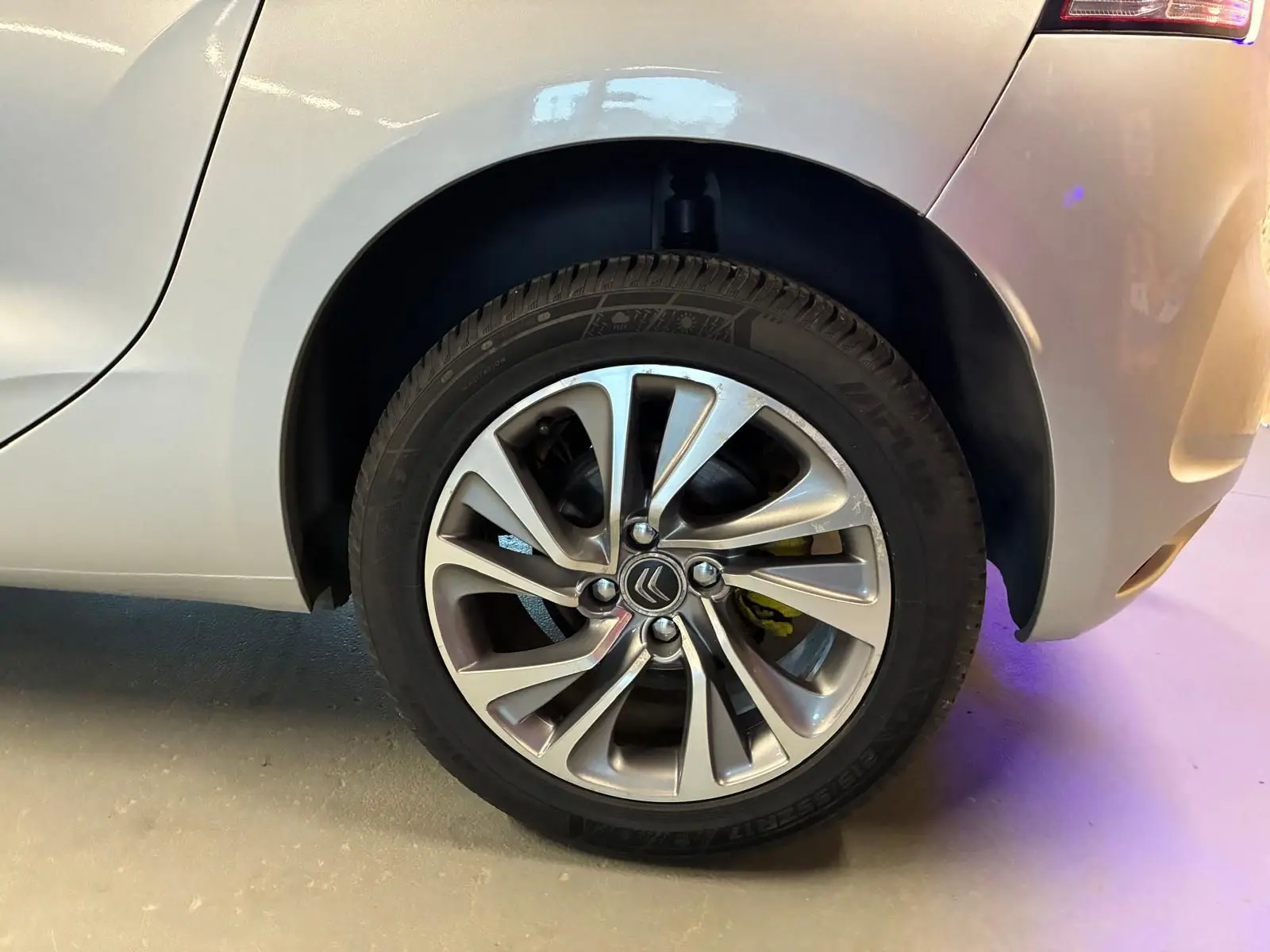 Gros plan sur la roue arrière droite gris métallisé d'une DS4 2014, mettant en valeur la jante alliage au design moderne.