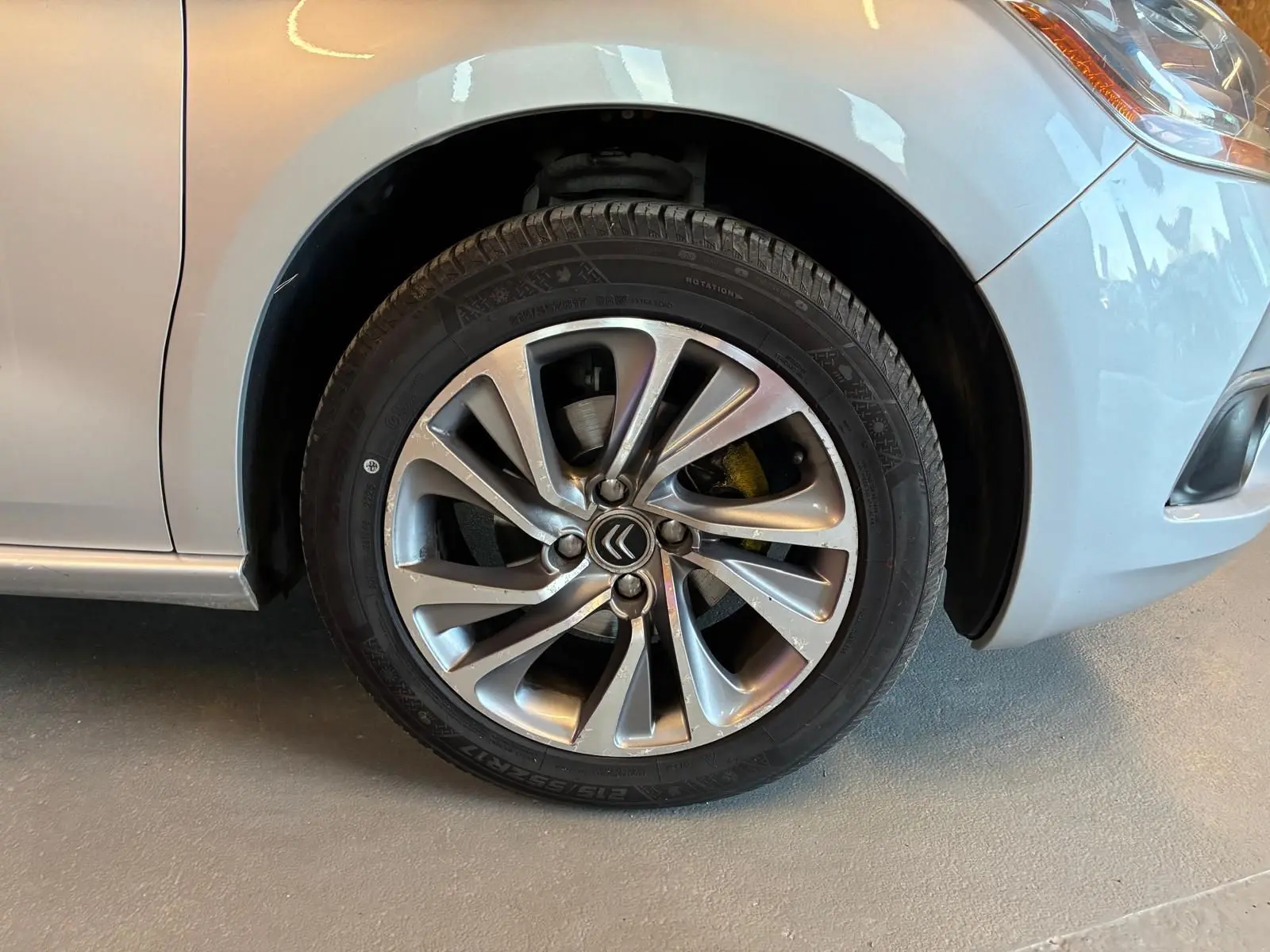 Gros plan sur la roue avant droite grise d'une DS4 2014 avec jante alliage et logo Citroën central.