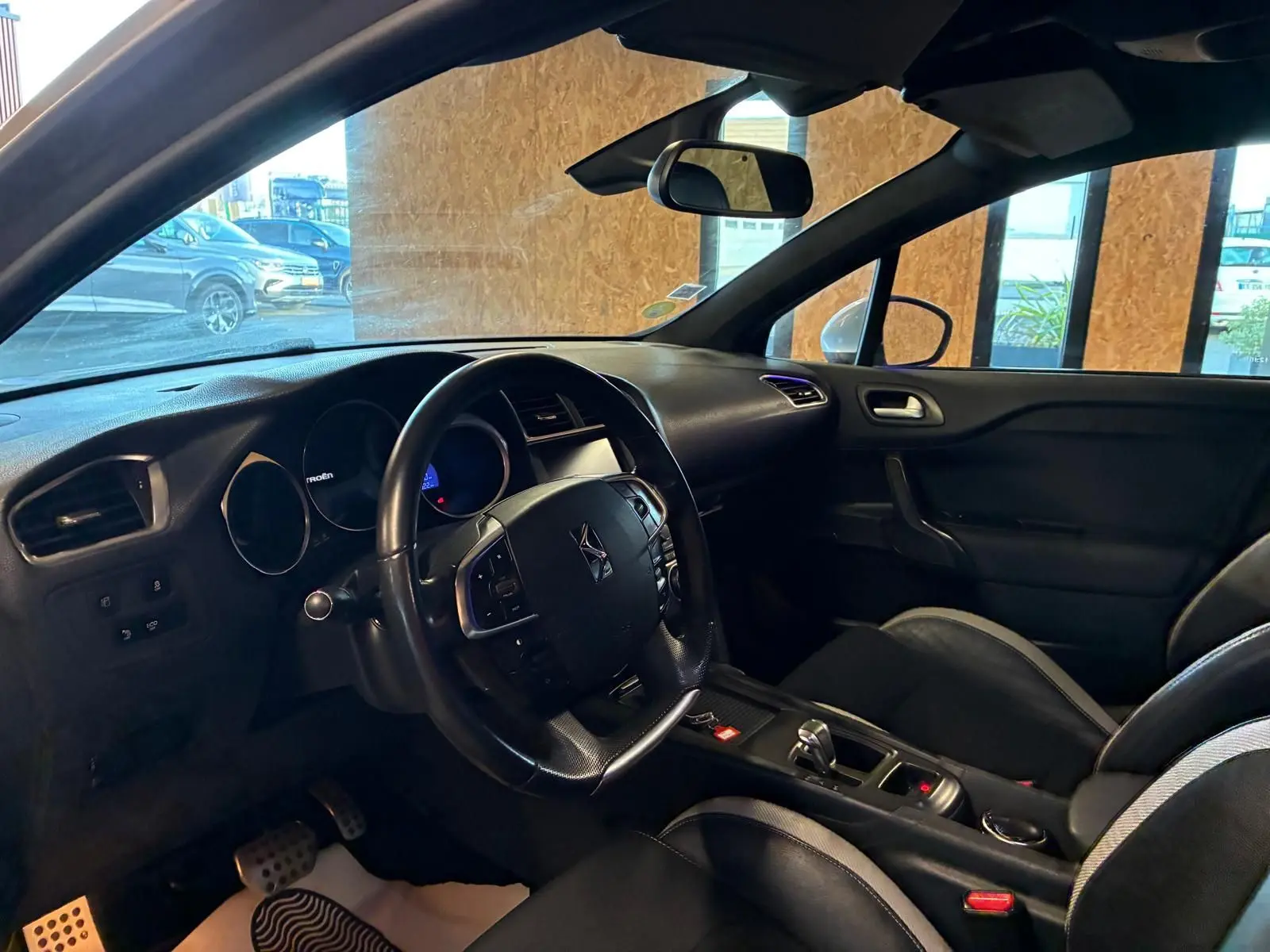 Intérieur côté conducteur de la DS4 gris, vue sur le volant multifonction et la console centrale avec boîte automatique.