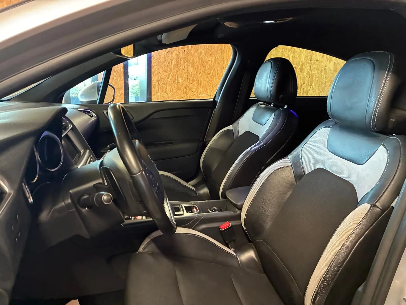 Intérieur de la DS4 gris, vue côté conducteur, sièges tissu gris et noir avec surpiqûres blanches.