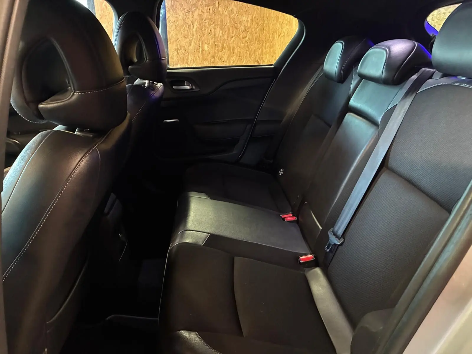 Vue intérieure côté droit des sièges arrière en tissu gris noir du DS4 gris diesel de 2014, avec ceintures de sécurité visibles.