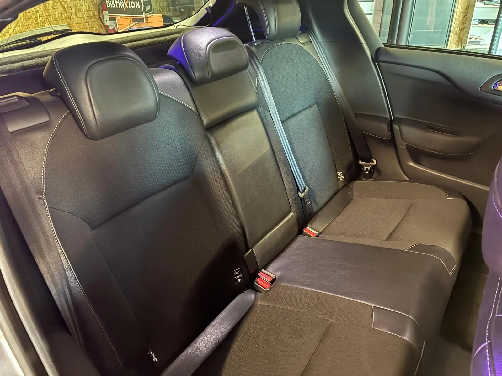 Vue intérieure côté droit des sièges arrière en tissu gris et noir du DS4 gris 2014 avec ceintures de sécurité visibles.