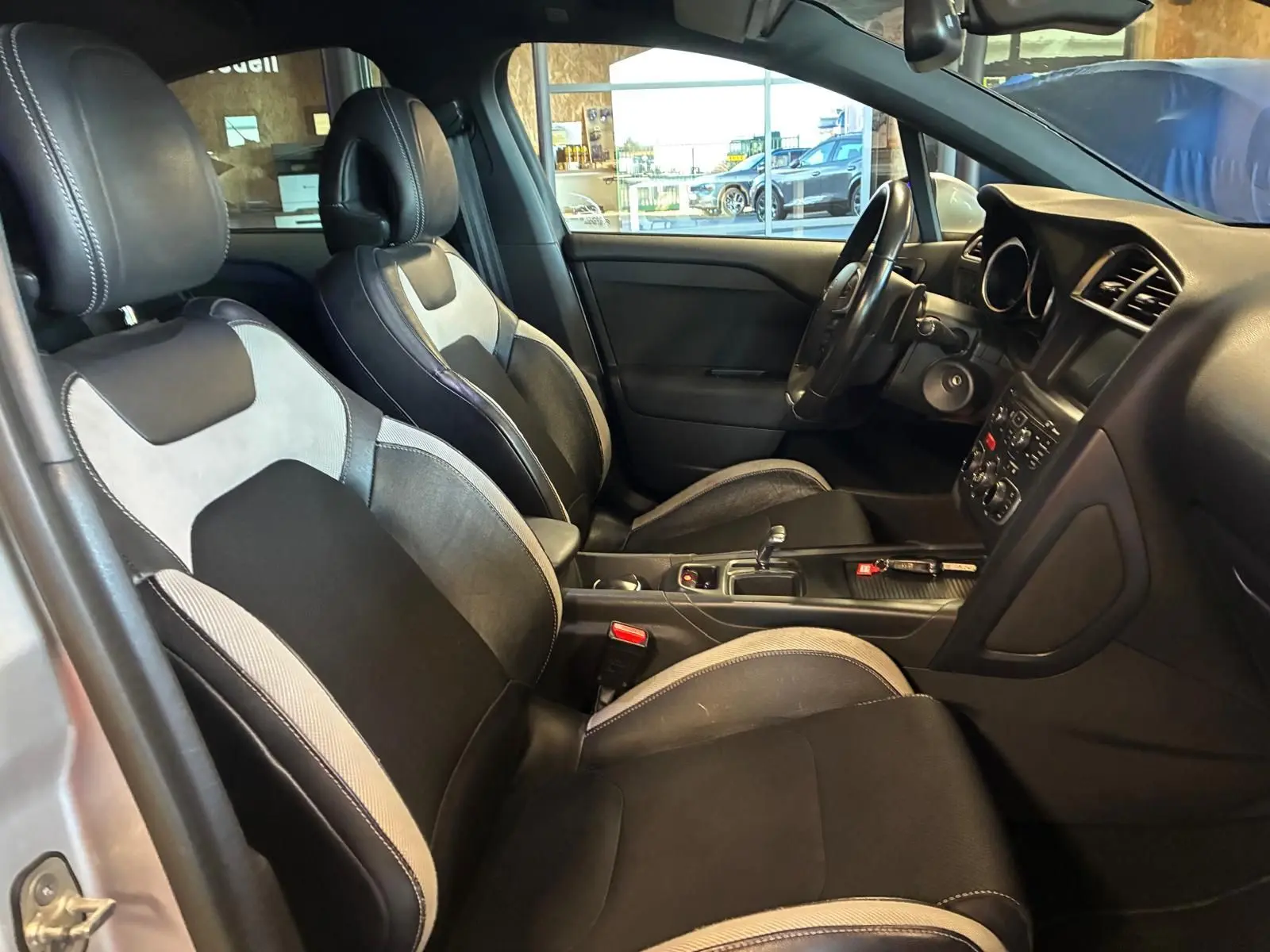 Vue intérieure côté droit de la DS4 2014, sièges tissu gris et noir avec console centrale et tableau de bord visibles.