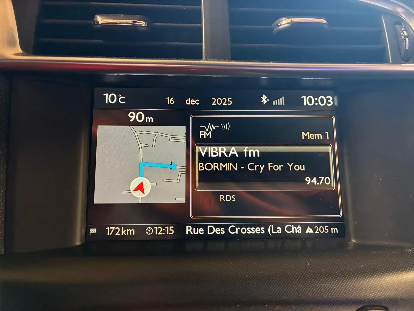 Écran central du tableau de bord du DS4 gris, affichant la navigation GPS et la radio FM en intérieur.