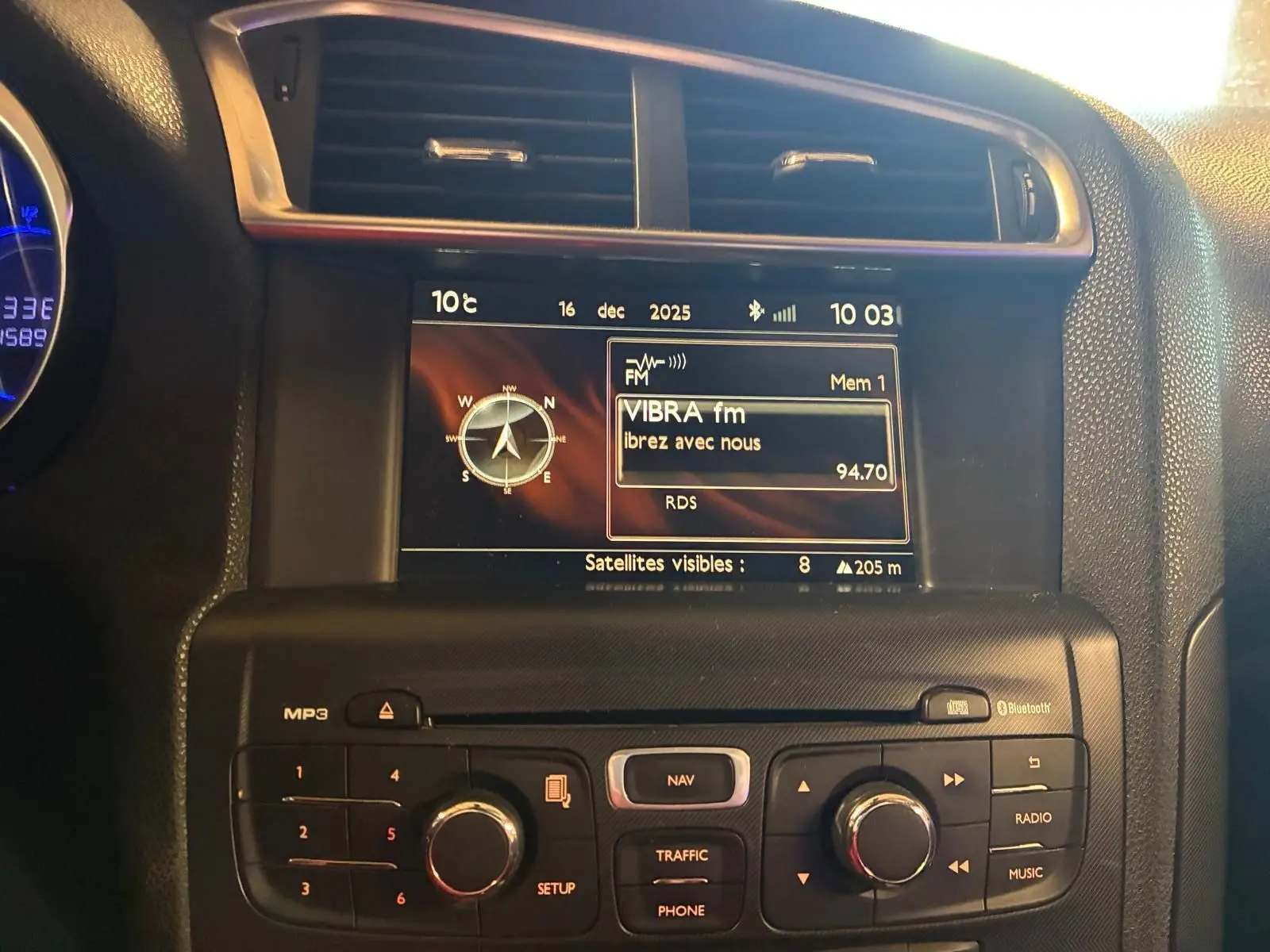 Vue rapprochée du tableau de bord de la DS4 gris, mettant en valeur l’écran central avec navigation et radio FM.