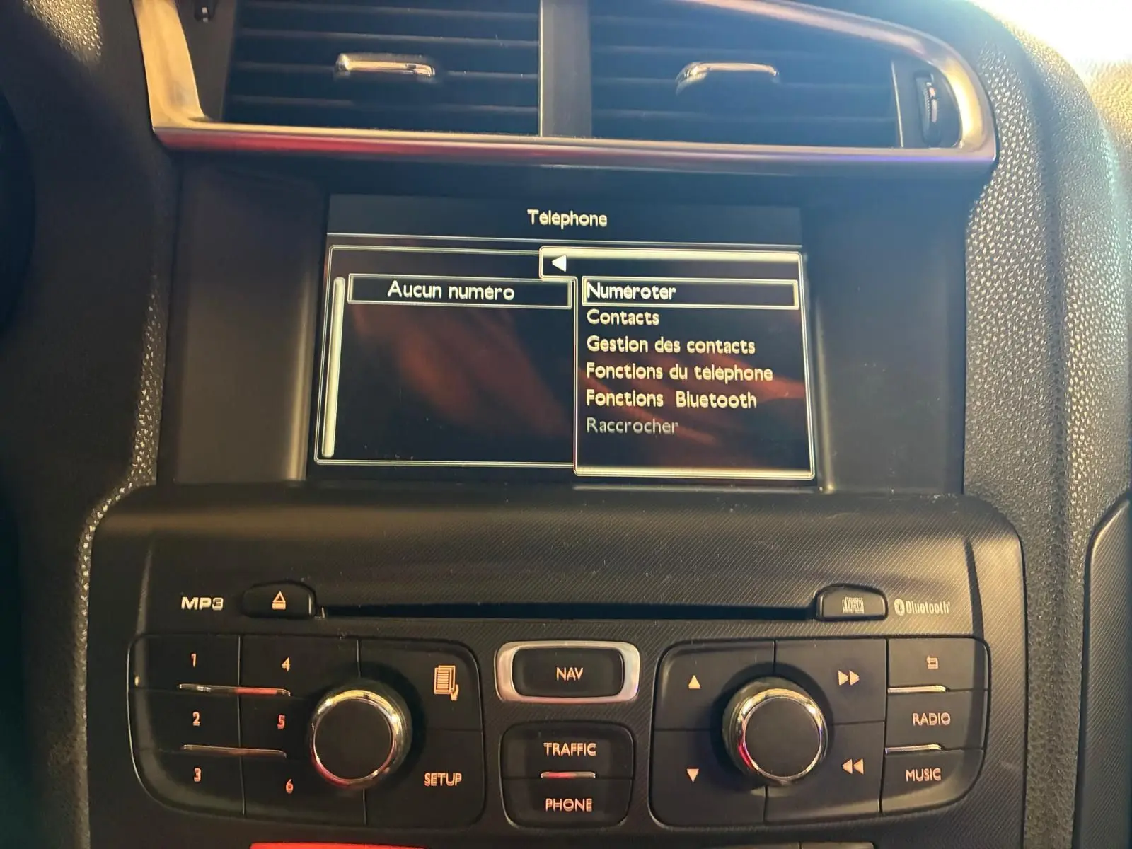 Vue rapprochée du tableau de bord gris noir du DS4 2014, écran central affichant le menu téléphone avec options Bluetooth.