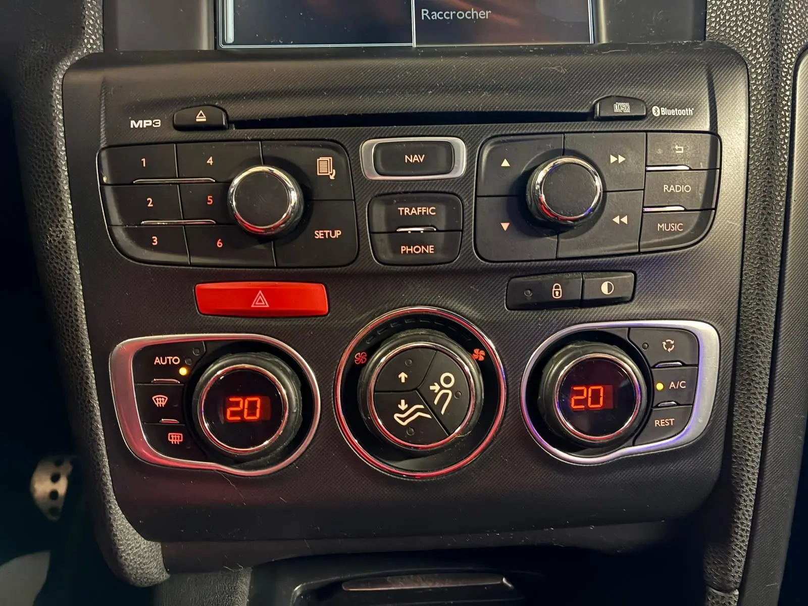 Gros plan sur la console centrale du DS4 gris 2014, montrant les commandes de climatisation et radio avec affichage digital rouge.