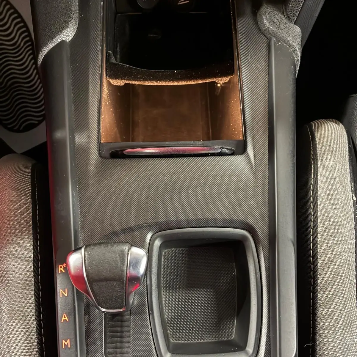 Vue plongeante sur la console centrale noire de la DS4 2014, avec levier de boîte automatique et rangement ouvert.