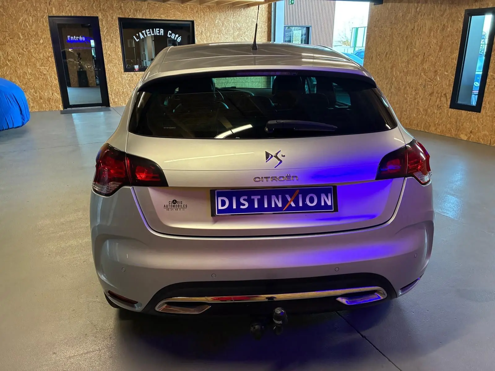 Vue arrière d'une DS4 gris métallisé 2014 avec feux rouges et attelage visible en intérieur showroom.