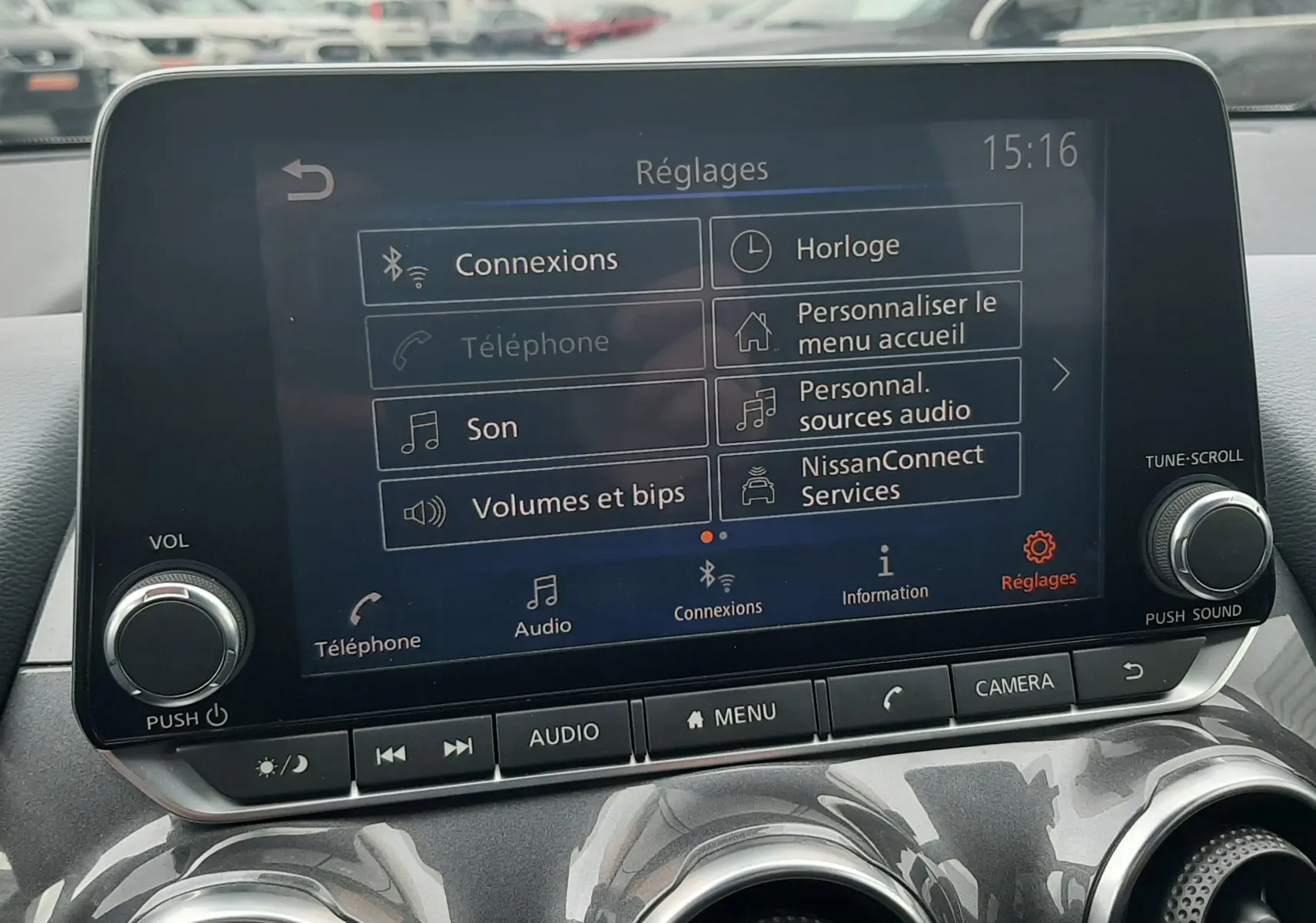 Écran tactile central du Nissan Juke gris 2020 affichant le menu Réglages avec commandes audio et connectivité.
