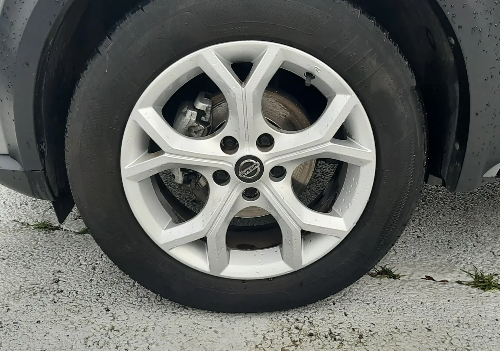 Gros plan sur la roue avant droite grise d'un Nissan Juke 2020 avec jante alliage et logo Nissan au centre.