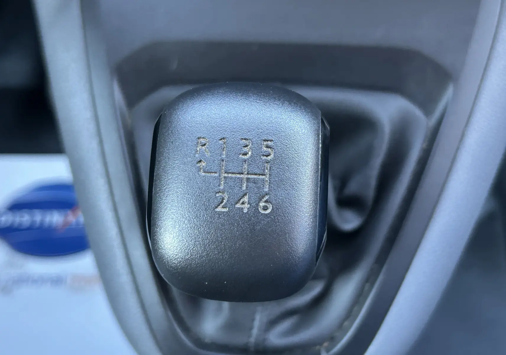 Gros plan sur le levier de vitesses manuel noir du Citroën Jumpy blanc, montrant les six rapports et la marche arrière.