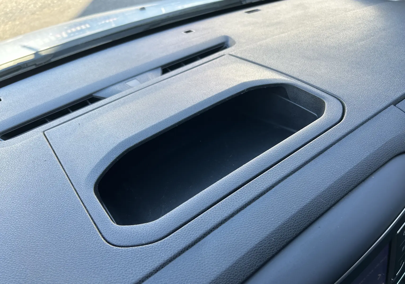 Détail du rangement intégré sur le tableau de bord gris foncé du Citroën Jumpy blanc, vue intérieure rapprochée.