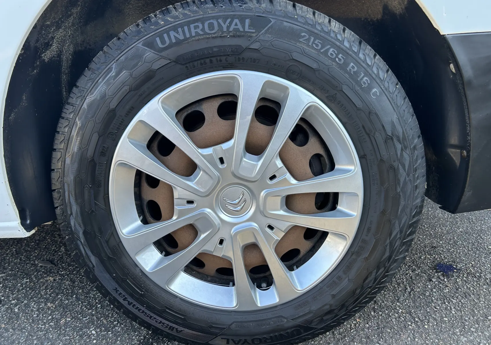 Gros plan sur la roue avant droite d'un Citroën Jumpy blanc de 2017 avec jante argentée et pneu Uniroyal.