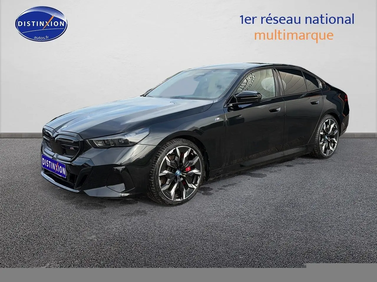 BMW Série 5 i5 M60 noir vue 3/4 avant droit avec jantes alu bicolores et calandre noire distinctive.