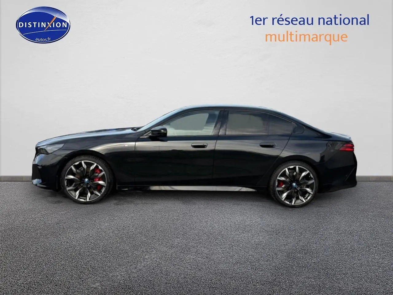 BMW Série 5 i5 M60 noir vue de profil côté gauche, avec jantes alu bicolores et étriers rouges visibles.