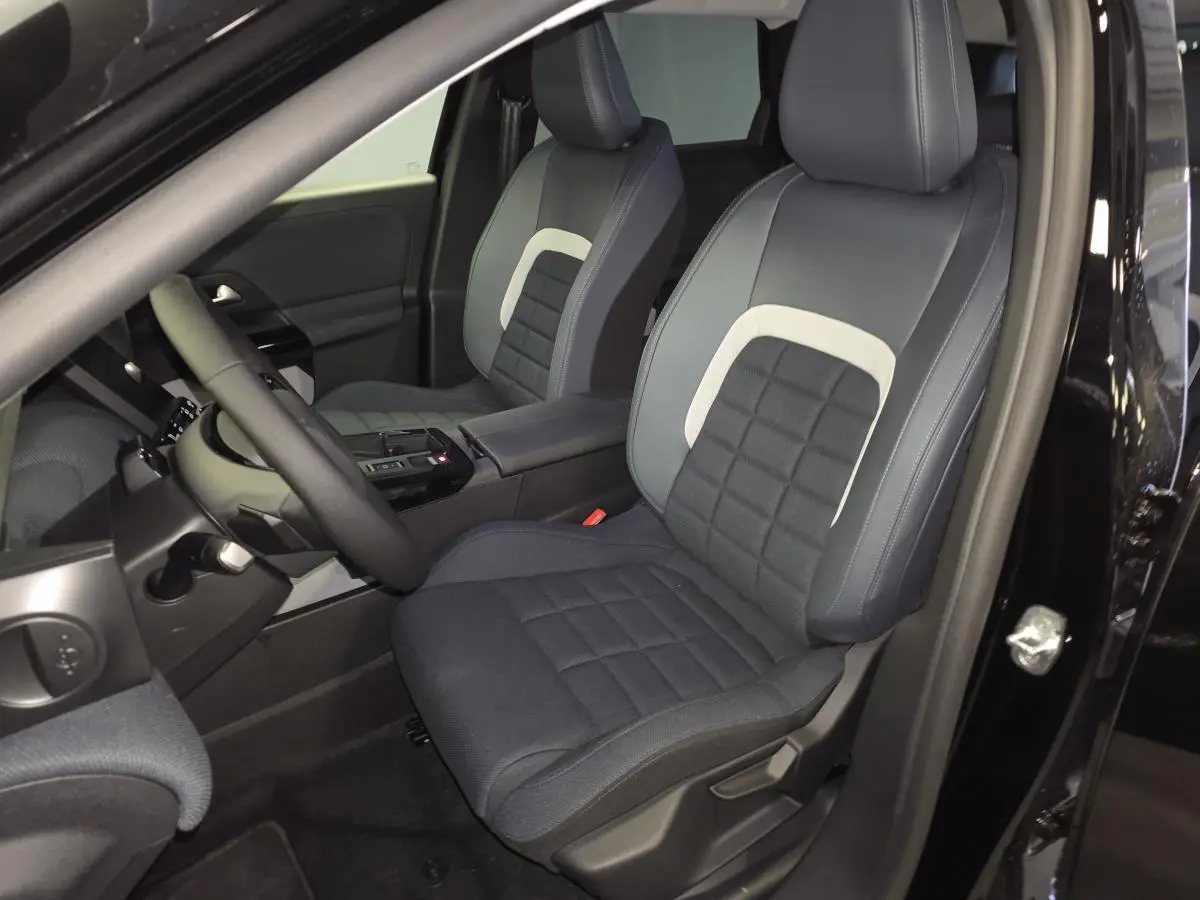 Vue intérieure côté conducteur du Citroën C5 Aircross noir 2026, sièges avant en tissu bicolore avec console centrale noire.