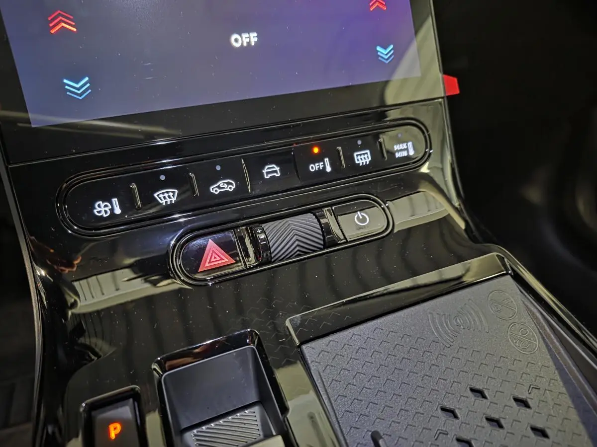 Gros plan sur la console centrale noire brillante du Citroën C5 Aircross 2026 avec commandes climatisation et recharge sans fil.
