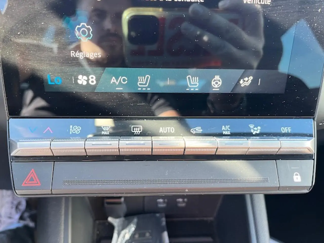 Gros plan sur la console centrale tactile du Renault Symbioz 2025, affichant les commandes de climatisation et sécurité.