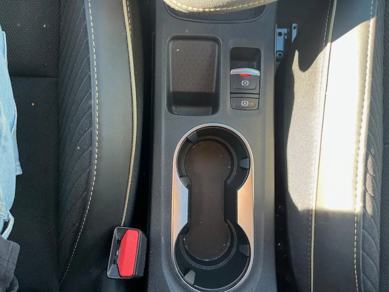 Vue plongeante sur la console centrale noire avec porte-gobelets et frein de parking électrique du Renault Symbioz 2025.