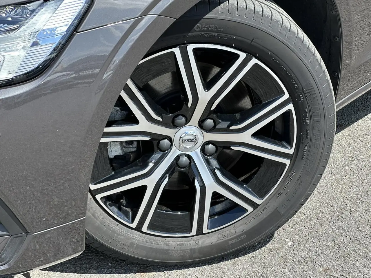 Gros plan sur la jante alliage 17 pouces noire et diamant du côté avant gauche d'une Volvo S60 gris Platinium.