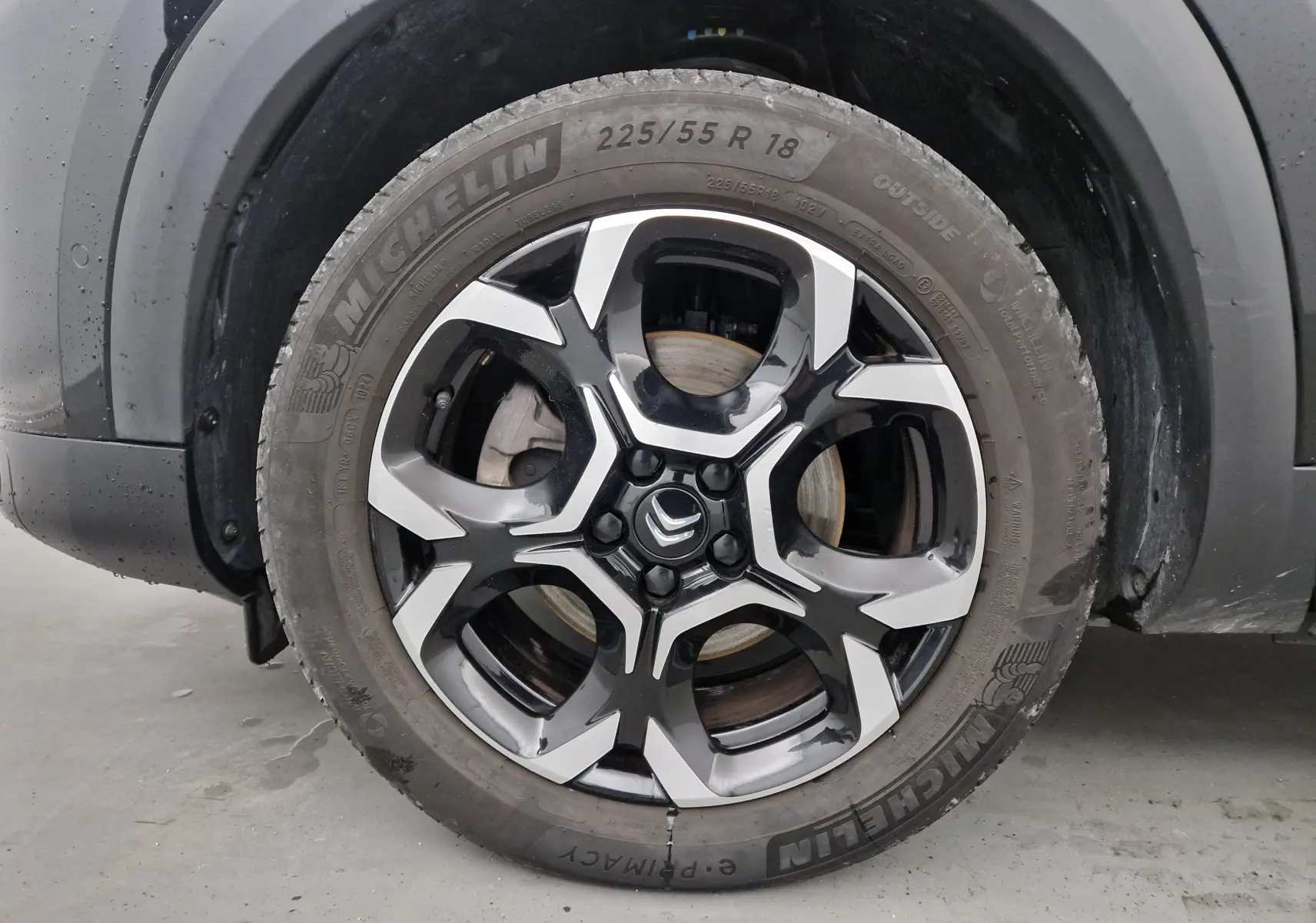 Gros plan sur la roue avant gauche noire d'un Citroën C5 Aircross 2024 avec jante alliage bicolore et pneu Michelin.