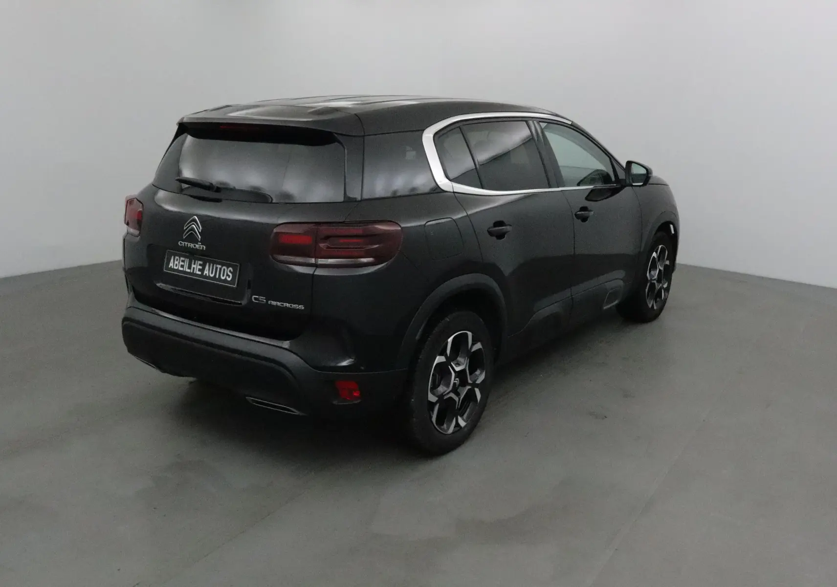 Citroën C5 Aircross noir vue 3/4 arrière droit, avec jantes alliage et vitres teintées dans un studio blanc.