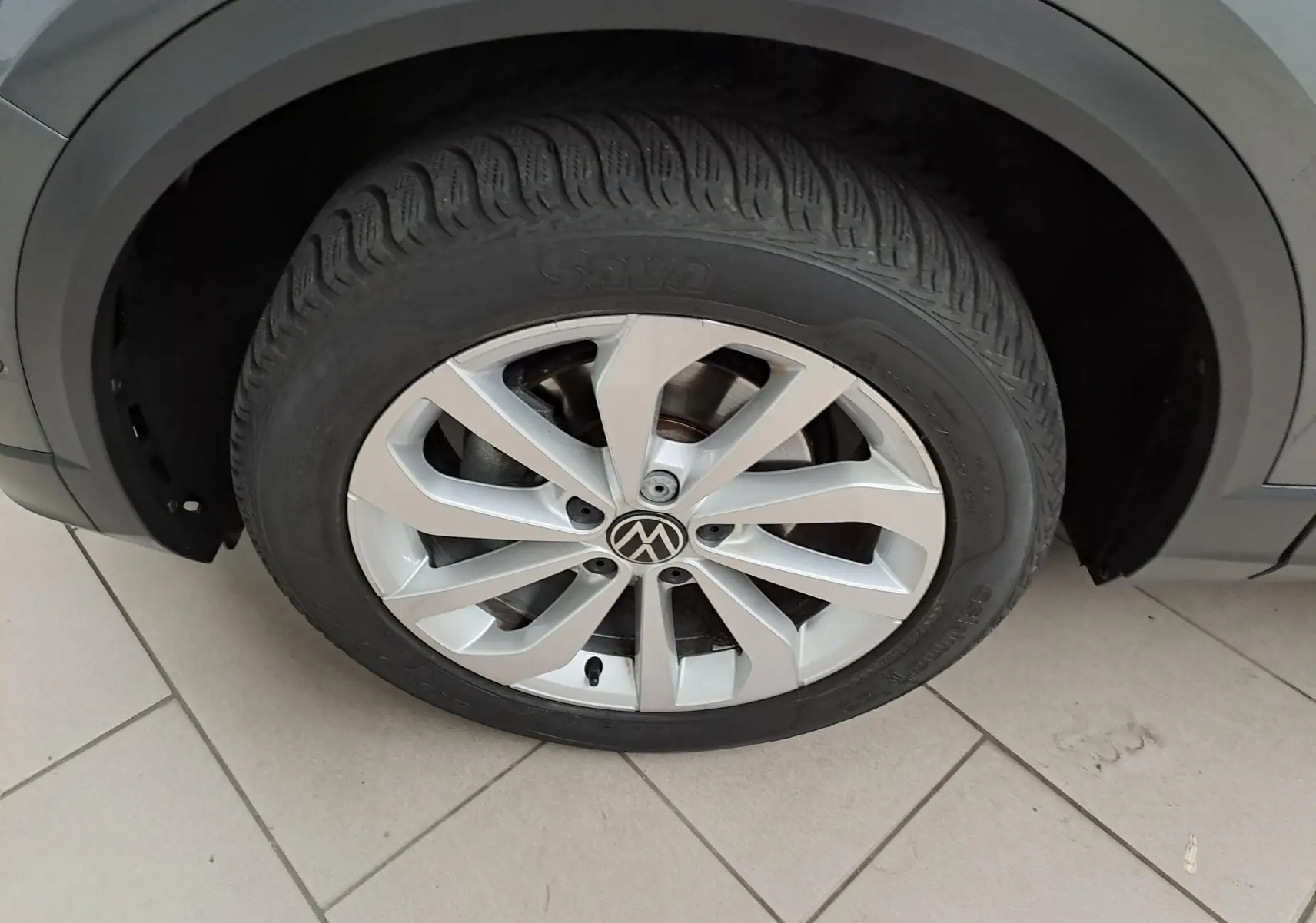 Gros plan sur la jante alliage 17'' Johannesburg du côté avant droit du Volkswagen T-Roc gris Indium 2024.