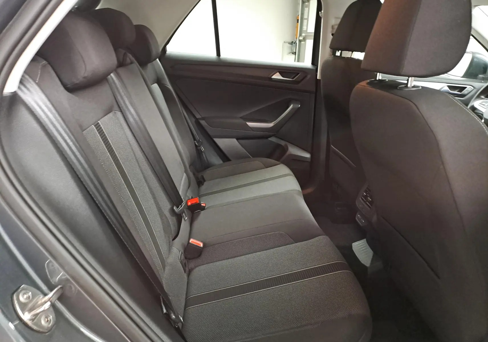 Vue intérieure côté gauche des sièges arrière en tissu noir du Volkswagen T-Roc 1.5 TSI 150 DSG7 LIFE 2024.