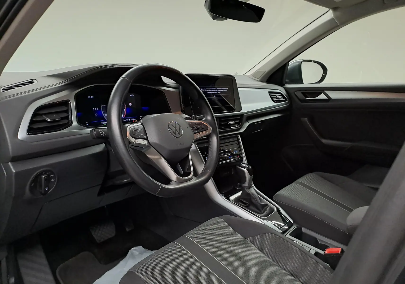 Intérieur avant droit du Volkswagen T-Roc 1.5 TSI 2024 avec tableau de bord numérique et volant multifonction noir.