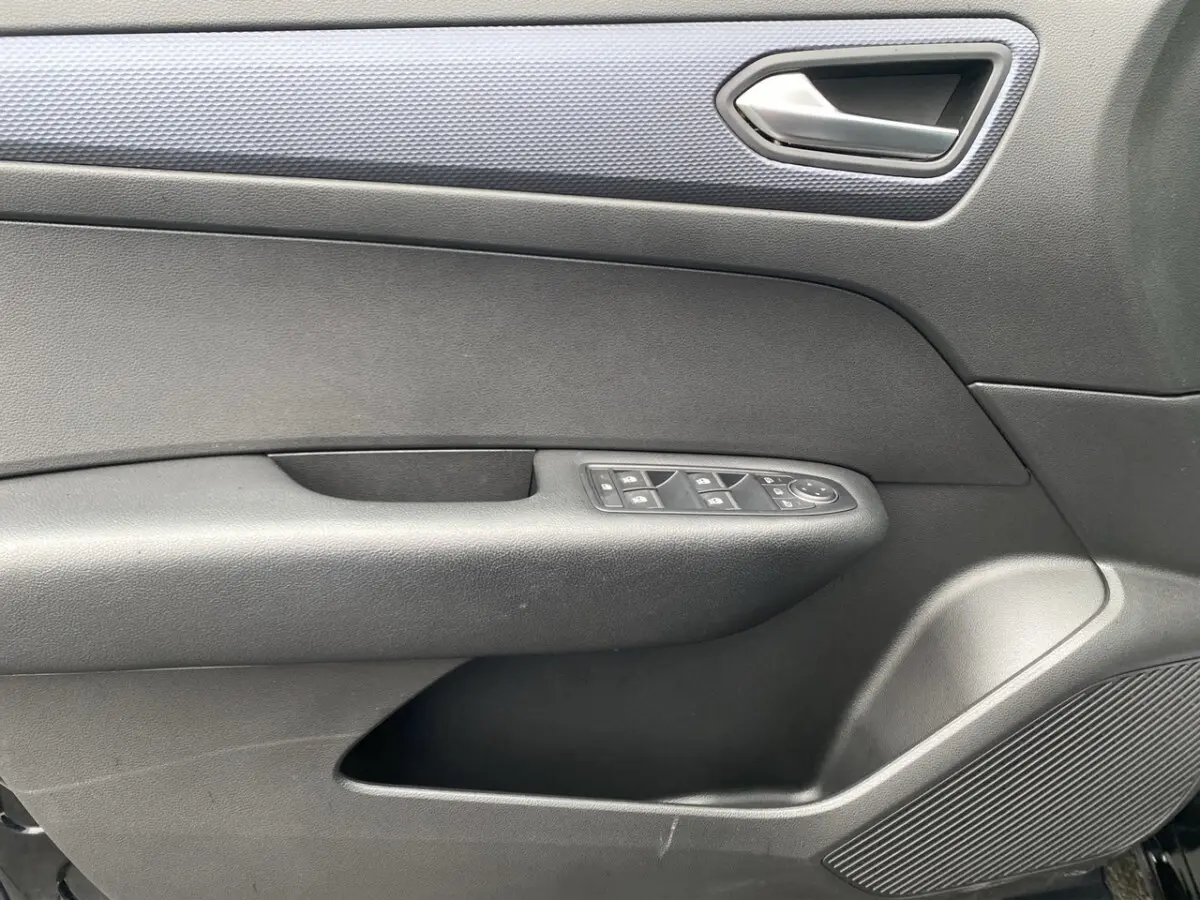Détail de la porte intérieure côté conducteur de la Renault Arkana 2024 noire, avec commandes de vitres et poignée argentée.