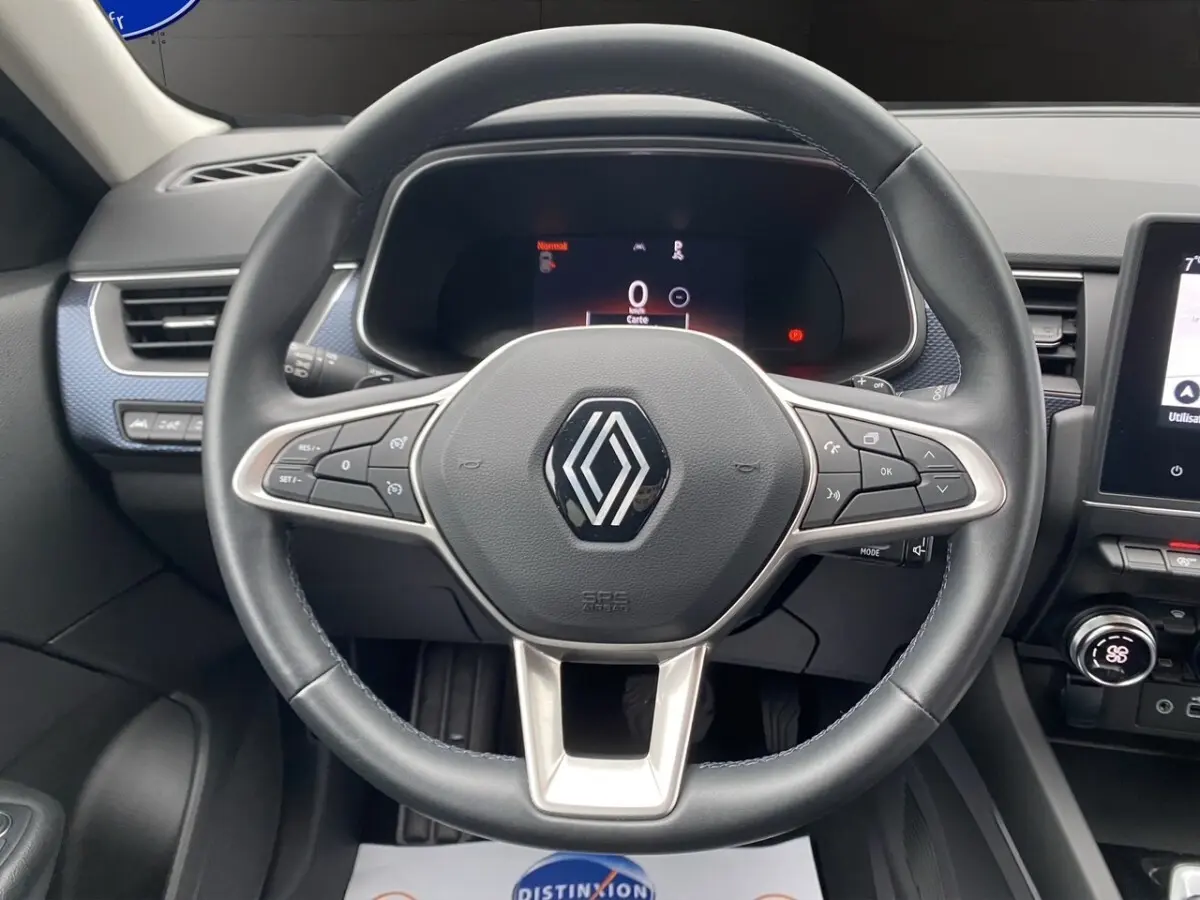 Vue rapprochée du volant cuir et alu du Renault Arkana noir 2024 avec tableau de bord numérique et écran tactile central.