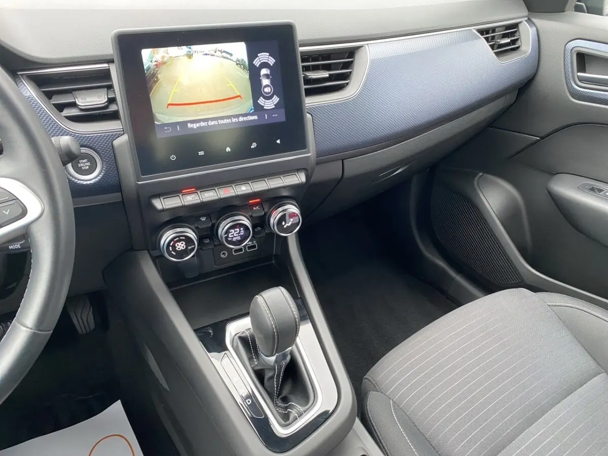 Vue intérieure côté passager du tableau de bord et console centrale du Renault Arkana noir avec écran tactile et levier de boîte auto.