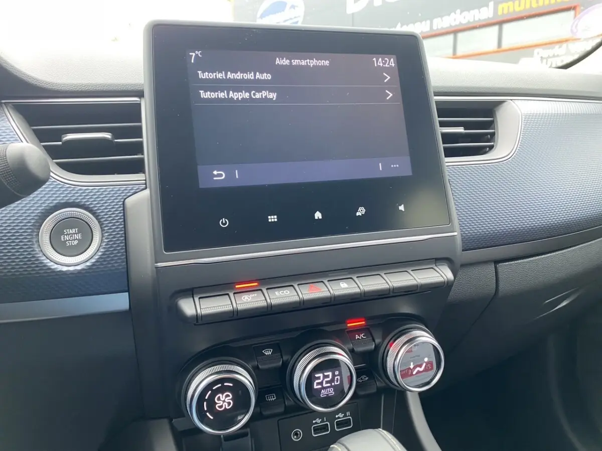Vue rapprochée du tableau de bord noir du Renault Arkana 2024 avec écran tactile central et commandes climatisation digitales.