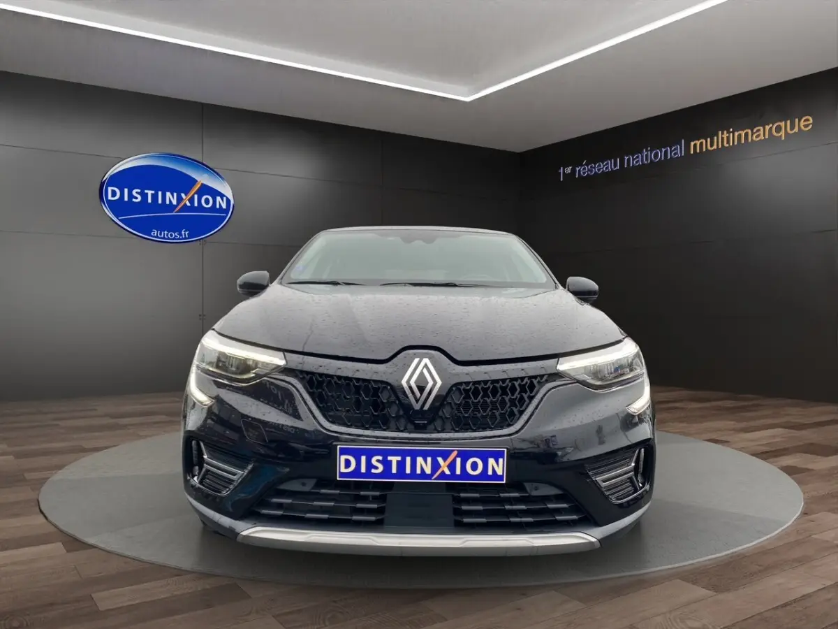 Renault Arkana noir vue de face, avec calandre hexagonale et feux LED allumés en showroom.