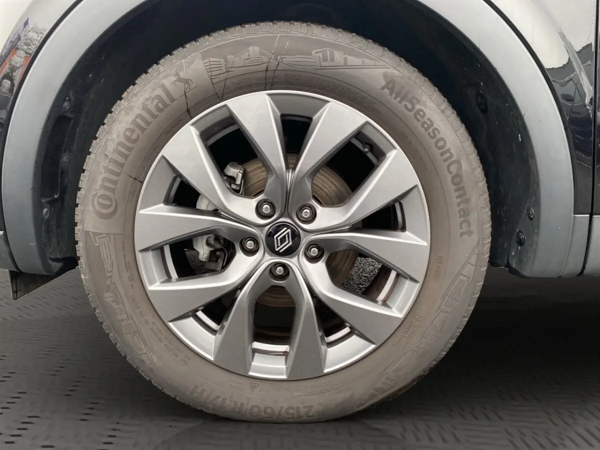 Gros plan sur la roue avant gauche d’un Renault Arkana noir, mettant en valeur la jante alliage argentée et le pneu Continental.