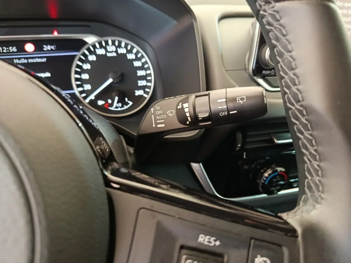 Gros plan intérieur sur le volant noir et la commande d’essuie-glace du Nissan Qashqai e-Power 2024.