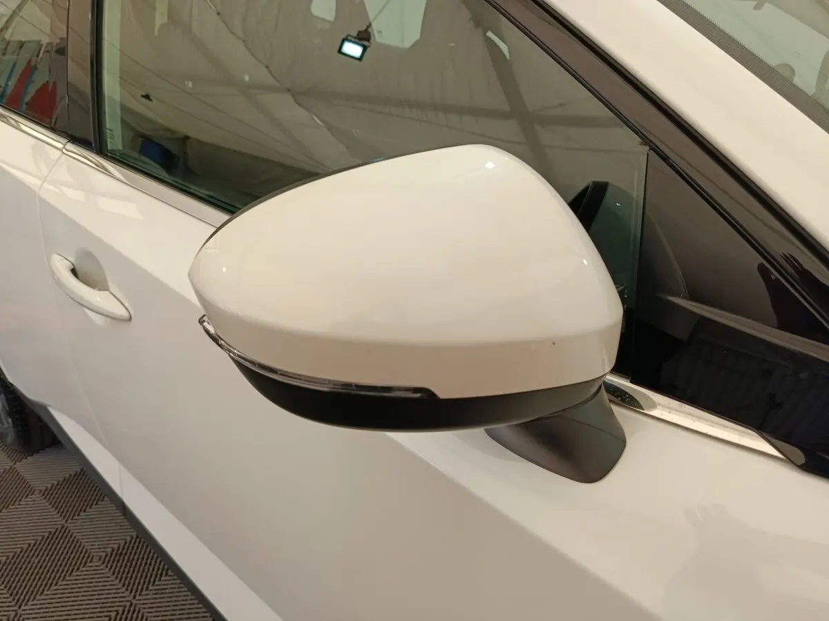 Rétroviseur droit blanc du Nissan Qashqai e-Power 2024 avec clignotant intégré, vue rapprochée côté conducteur.