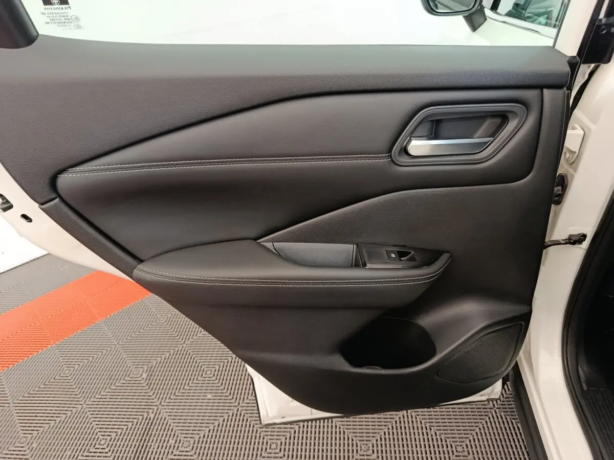 Porte intérieure côté gauche du Nissan Qashqai e-Power blanc, avec garniture noire et poignée argentée.