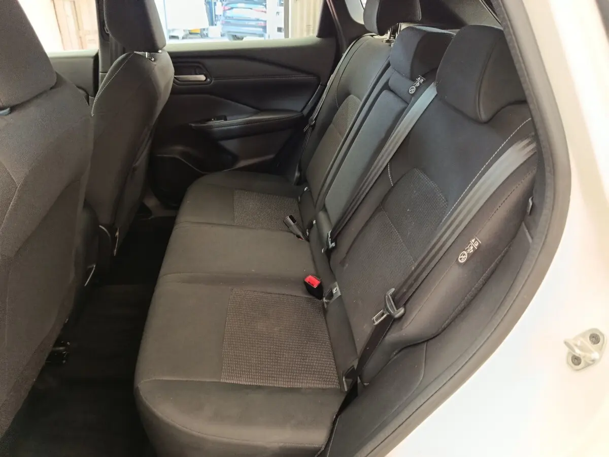 Vue intérieure côté droit des sièges arrière noirs du Nissan Qashqai e-Power 2024 avec ceintures de sécurité visibles.