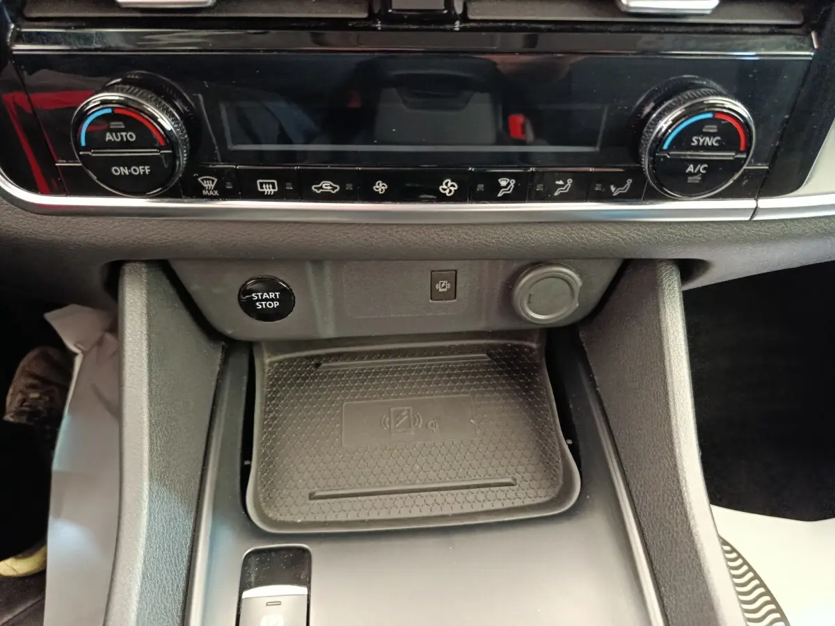 Gros plan intérieur sur la console centrale du Nissan Qashqai e-Power 2024, avec commandes climatisation et bouton start/stop.