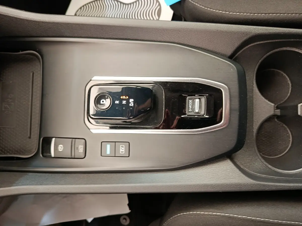 Vue rapprochée de la console centrale noire du Nissan Qashqai e-Power 190 Business Edition avec sélecteur de boîte auto et boutons de mode.